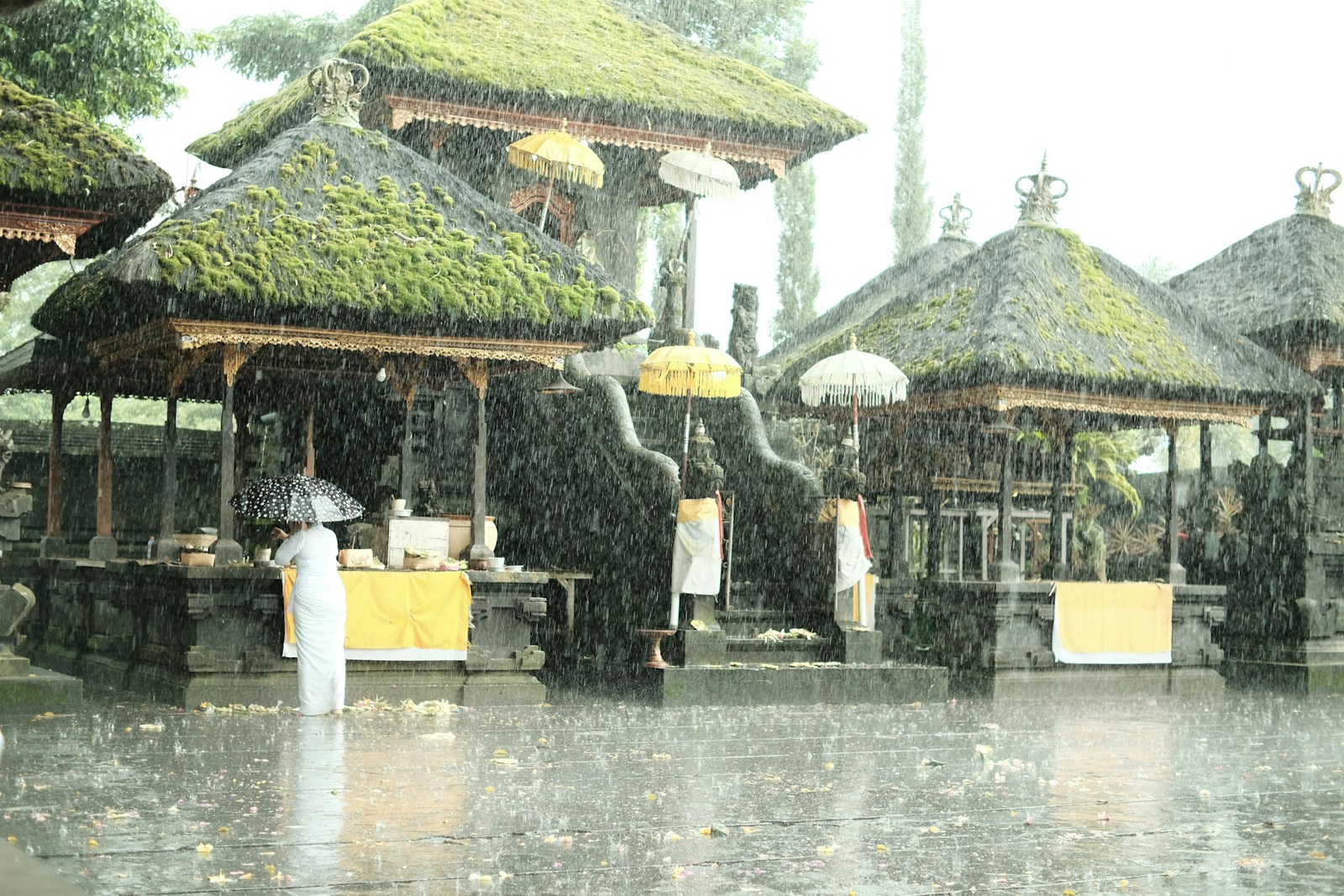 a person standing in the rain with an umbrella