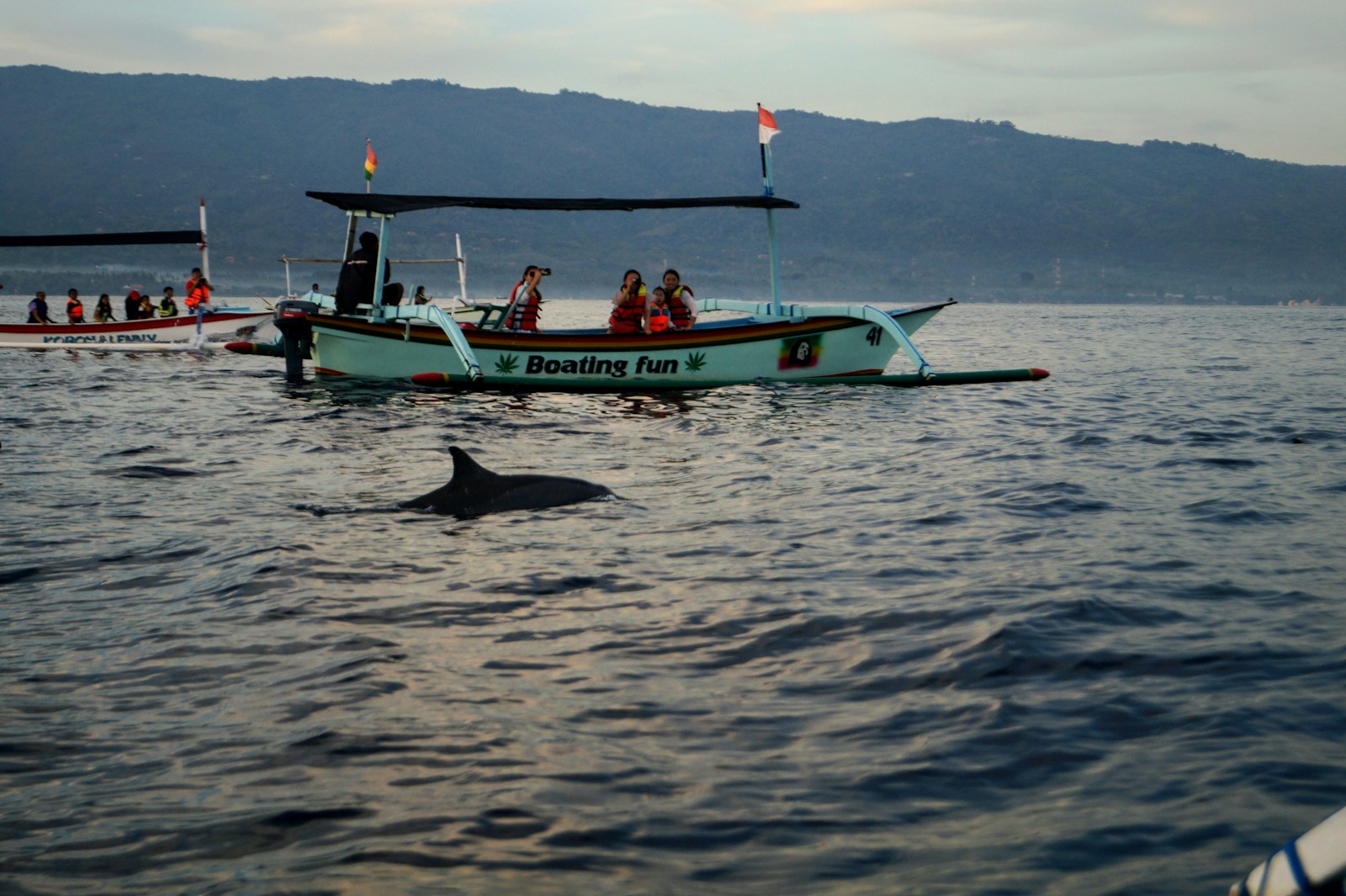 people riding on white and green boat on sea during daytime